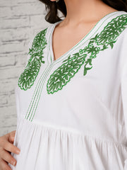 White maternity dress with green floral embroidered V-neckline