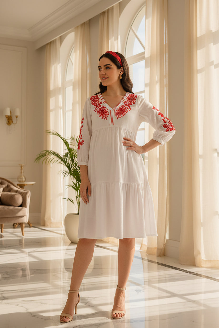 White maternity dress with red floral embroidery and V-neckline