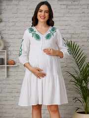 White maternity dress with green floral embroidery and V-neckline