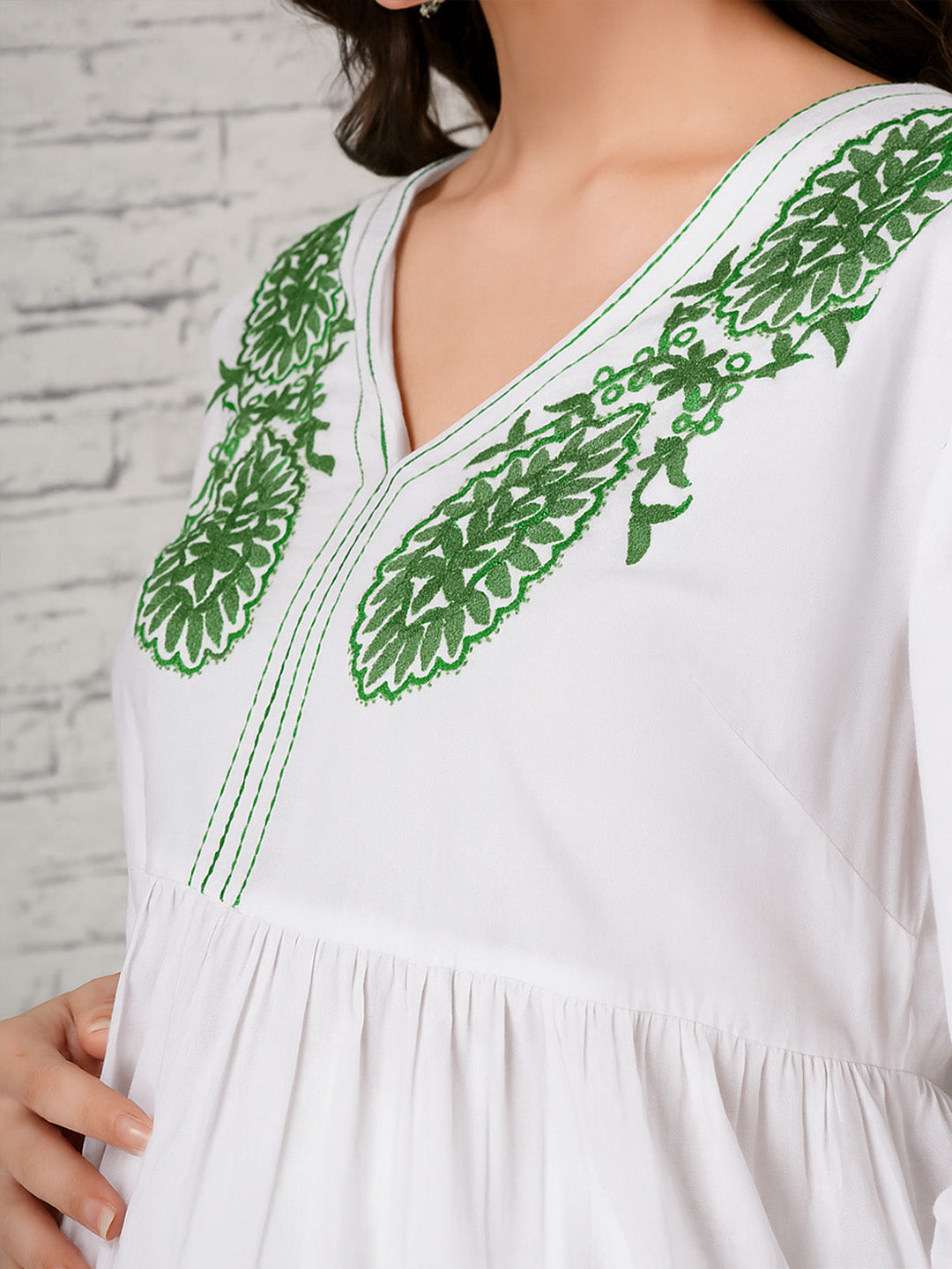 White maternity dress with green floral embroidered V-neckline